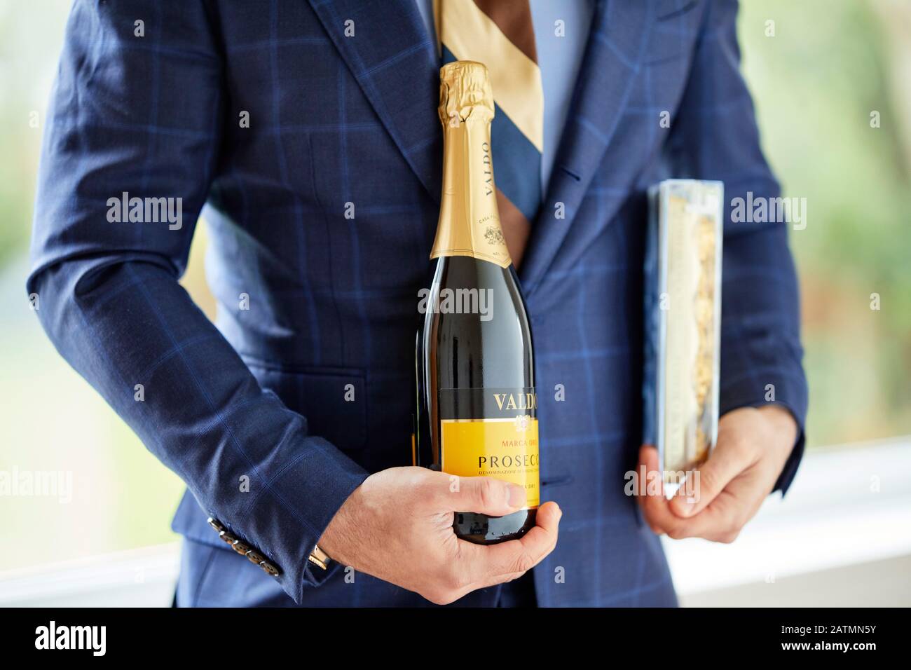 Man holding box of chocolates and a bottle of wine Stock Photo