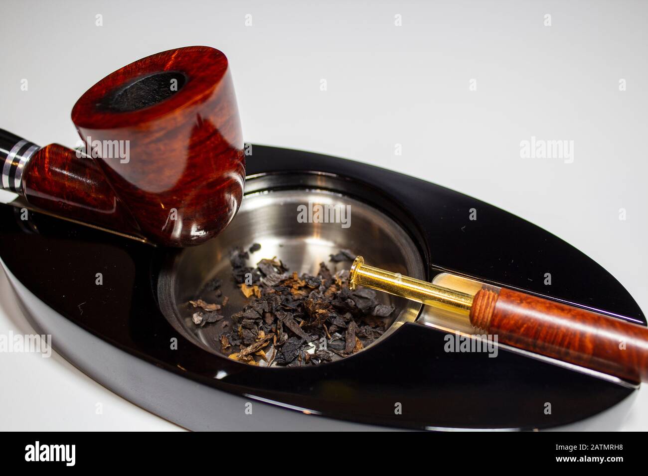 cigarette stoppers fresh tobacco in ashtray with pipe stopper and pipe Stock Photo