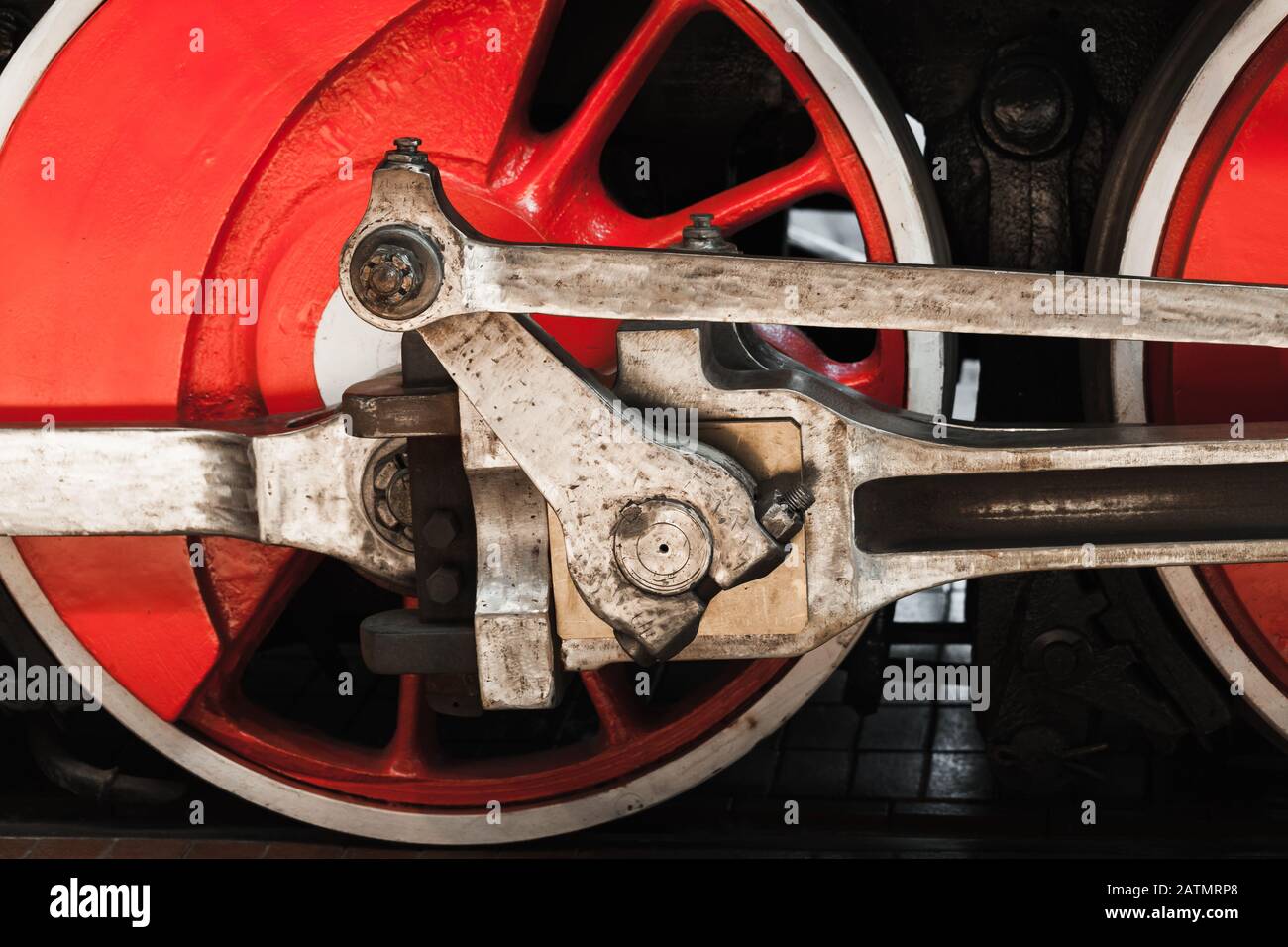 Red wheel of vintage steam locomotive with connecting rod, close-up photo Stock Photo