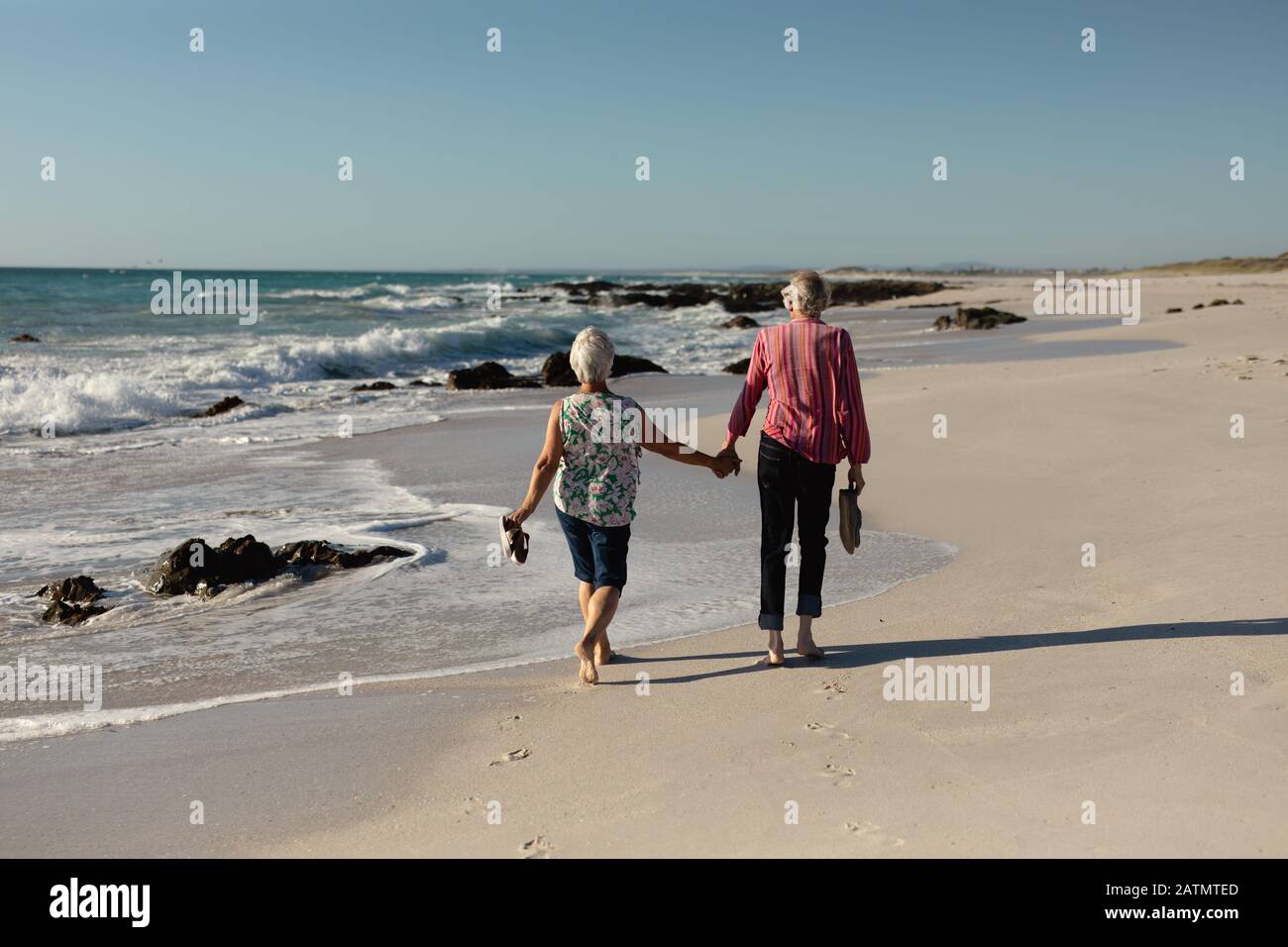 Old couple walking at the beach Stock Photo - Alamy