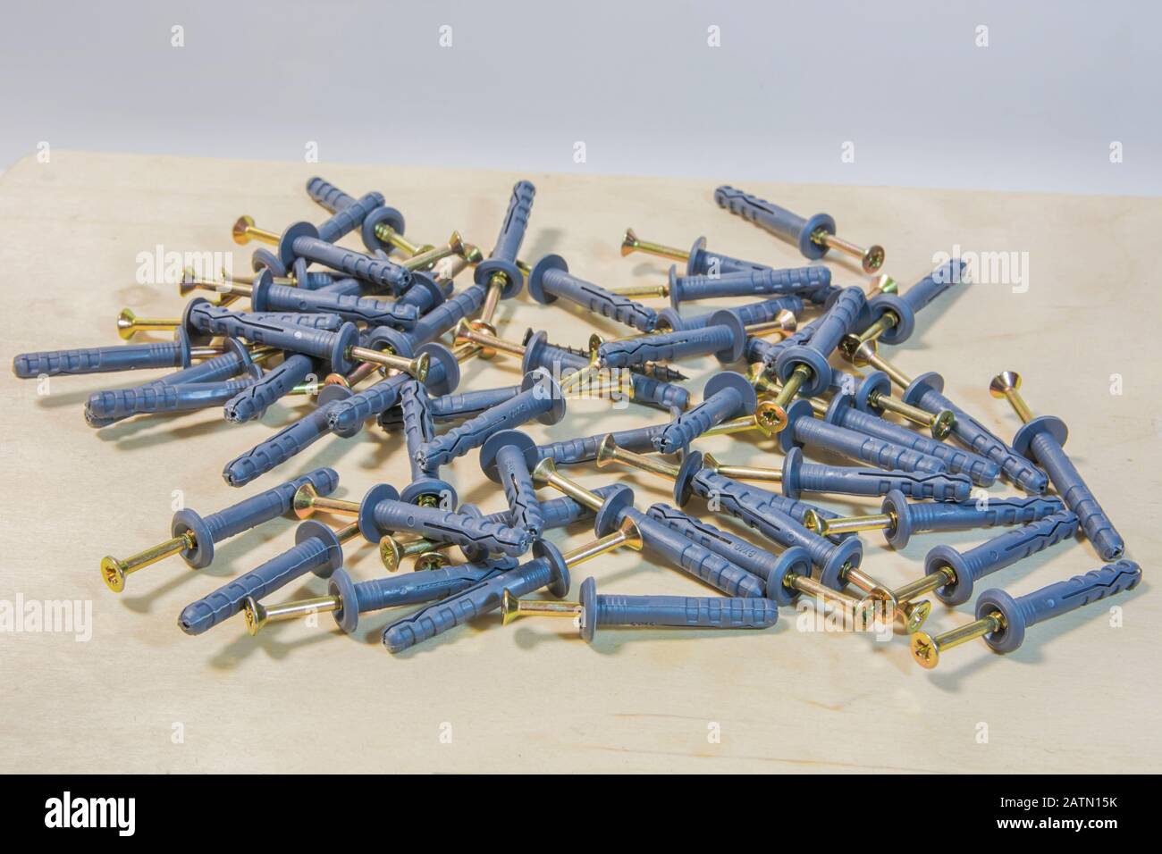 Dowel nails on wood background. Set of wall plugs. Stock Photo