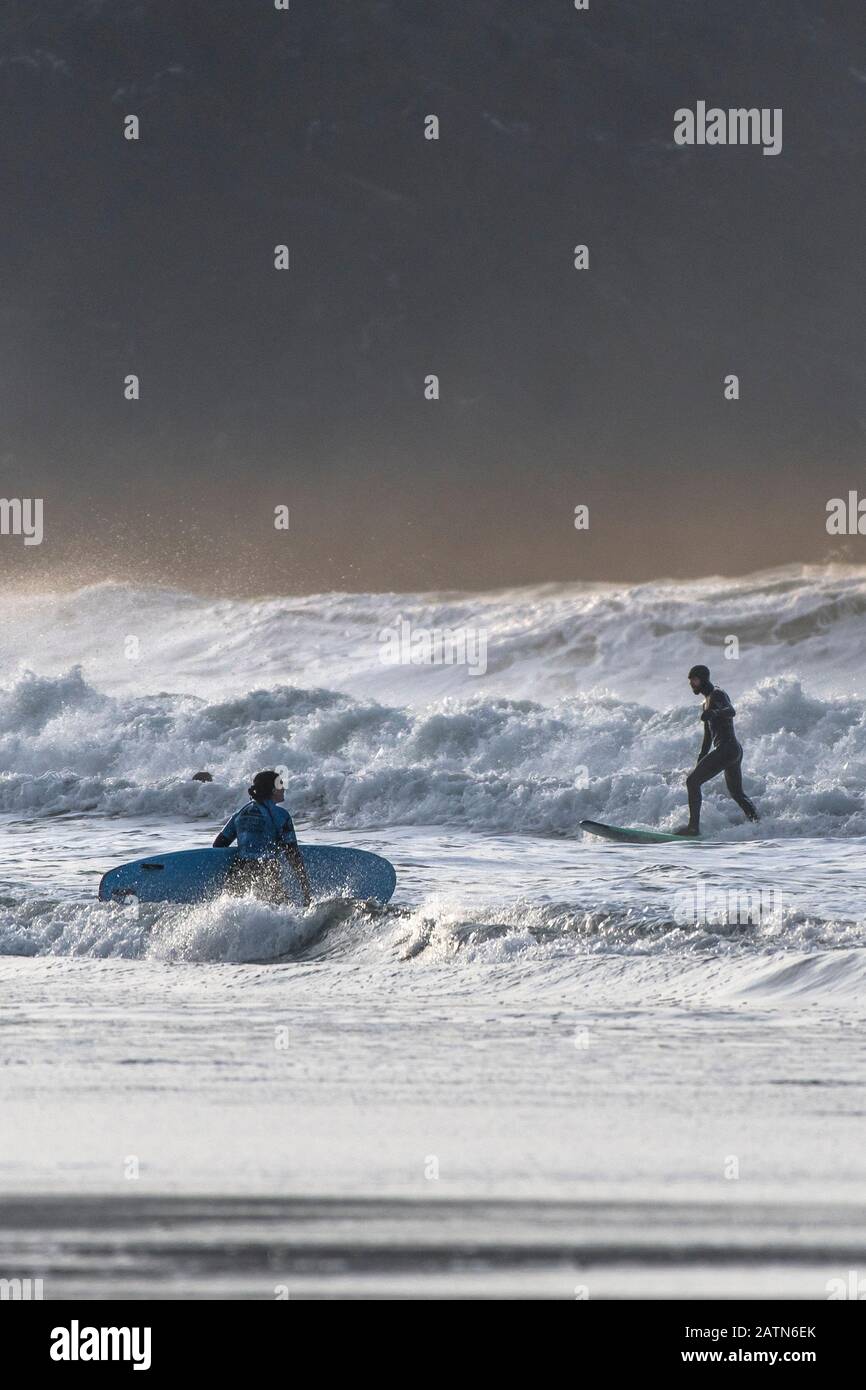 Surfers in rough sea conditions at Fistral Beach in Newquay in Cornwall. Stock Photo