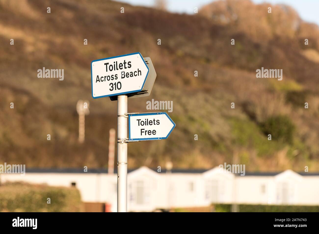 A signpost with signs giving directions to toilets at Porth Beach in Newquay in Cornwall. Stock Photo