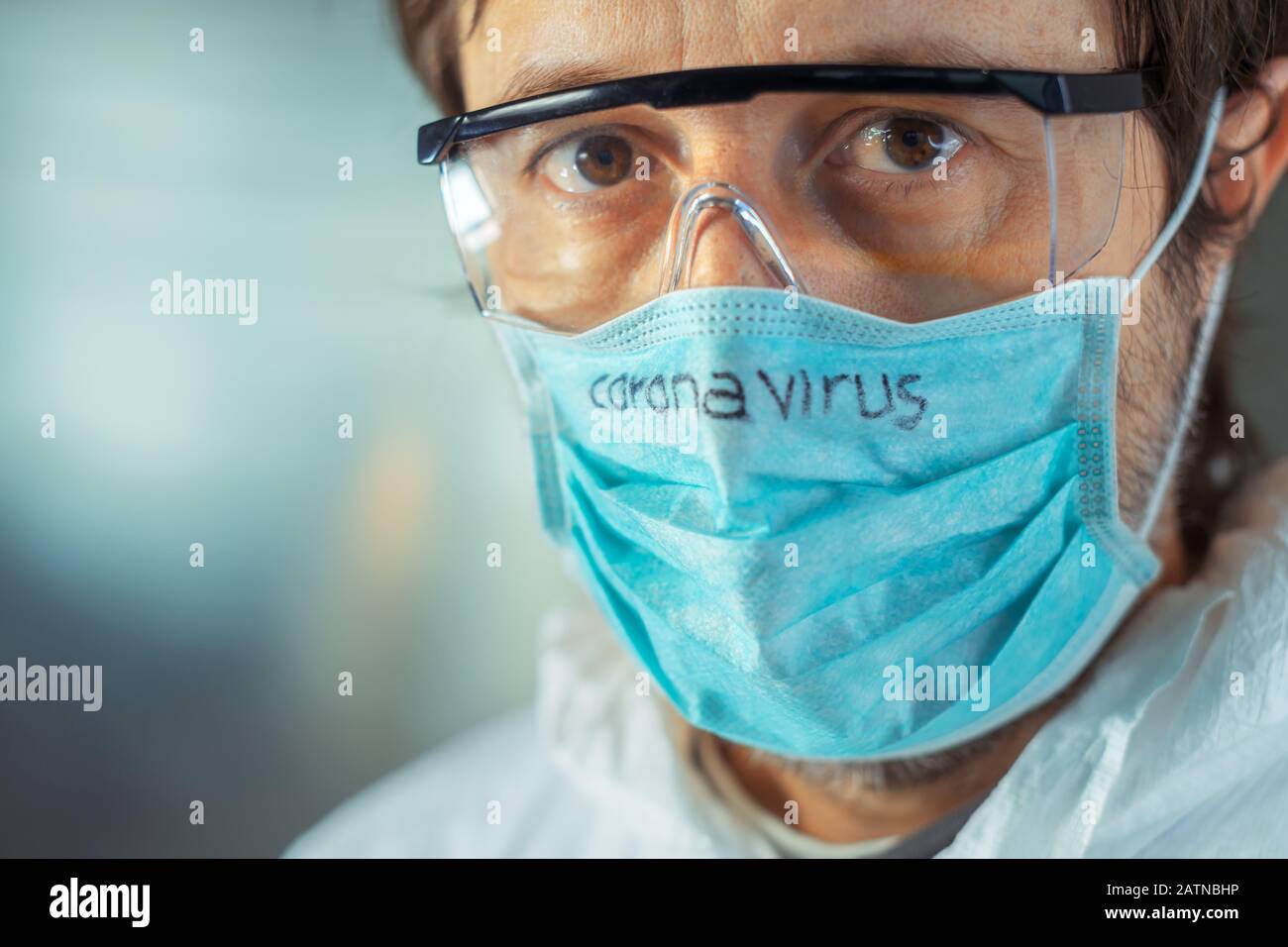 Medical worker wearing Coronavirus face protective mask, close up head shot portrait Stock Photo