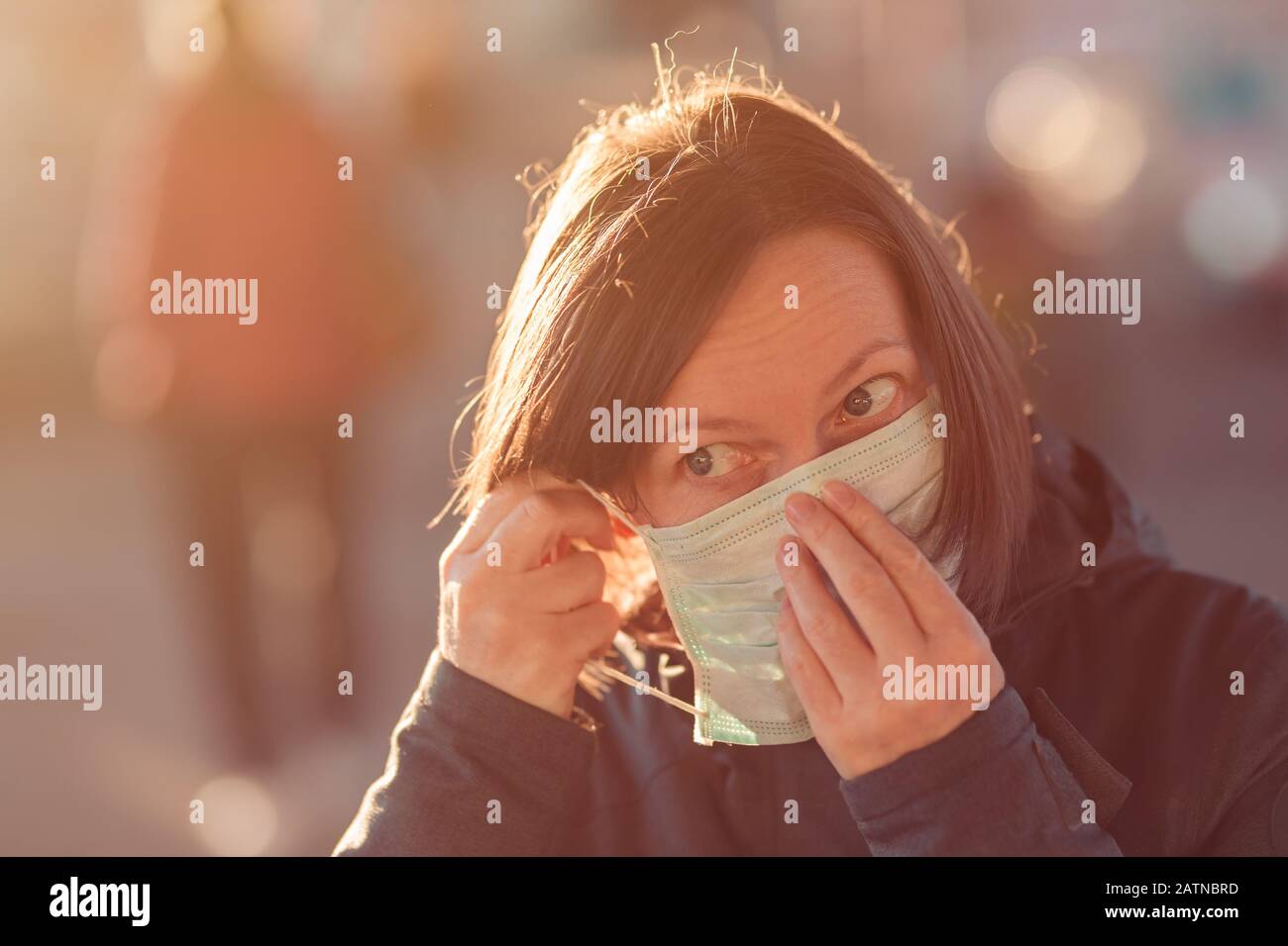 Woman with face protective mask standing on the street, protection from epidemics respiratory virus infections Stock Photo