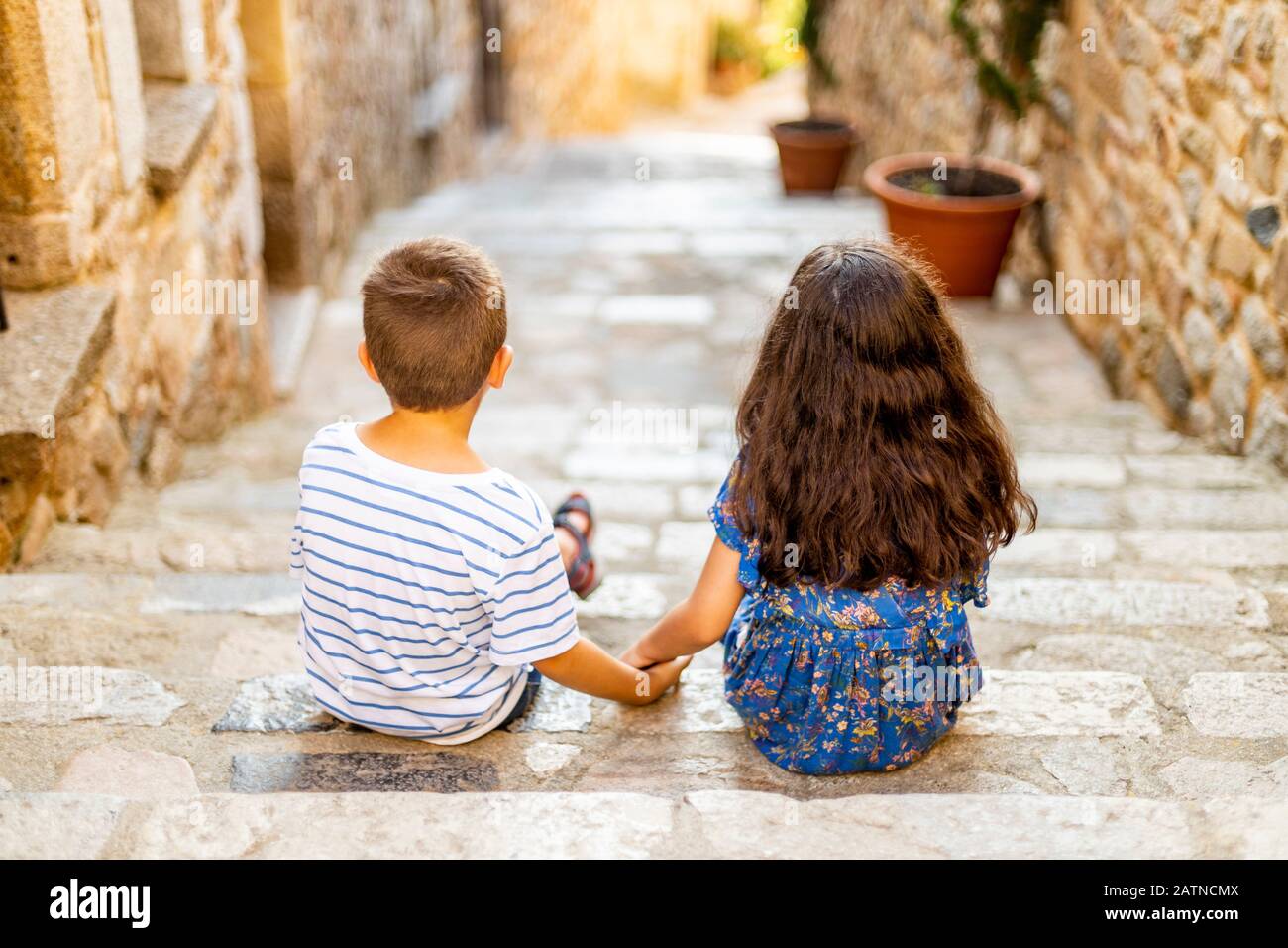Two little kids holding her hands on a summer day Stock Photo