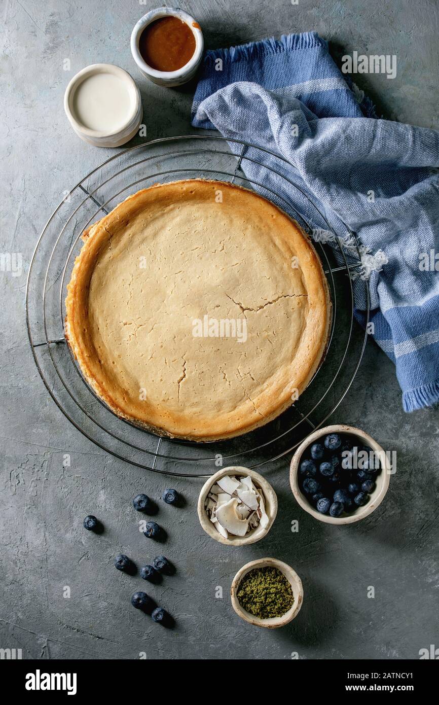 Homemade cane sugar baked cheesecake on cooling rack with variety of