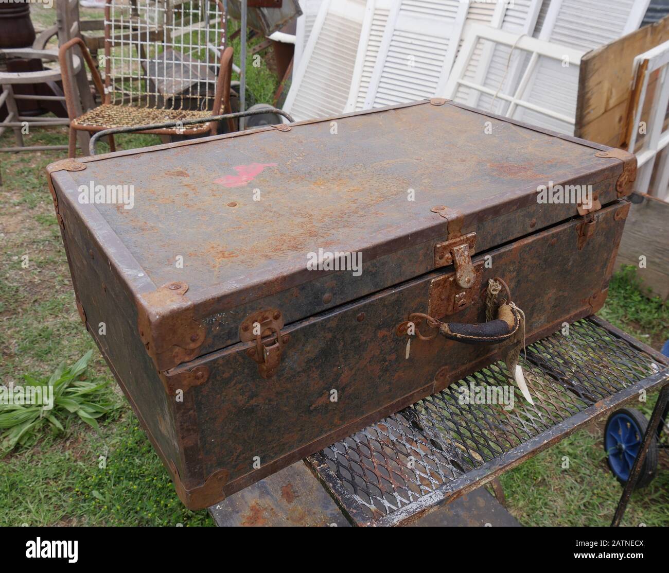 Old rusty metal box and several other junk items at a garage sale Stock