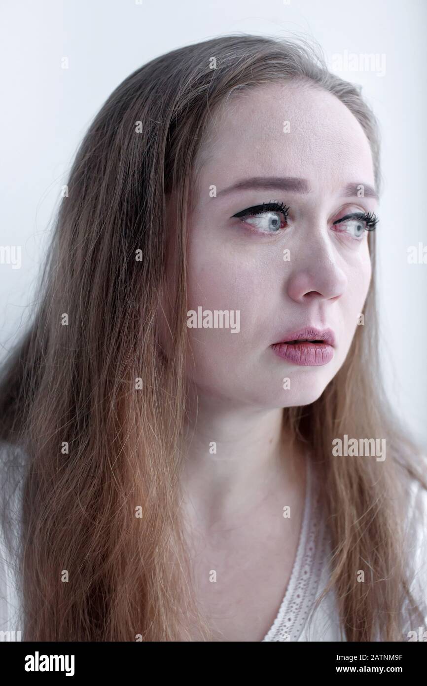 Expressive close-up portrait of crying woman with tears running on her face, beautiful upset emotional woman Stock Photo