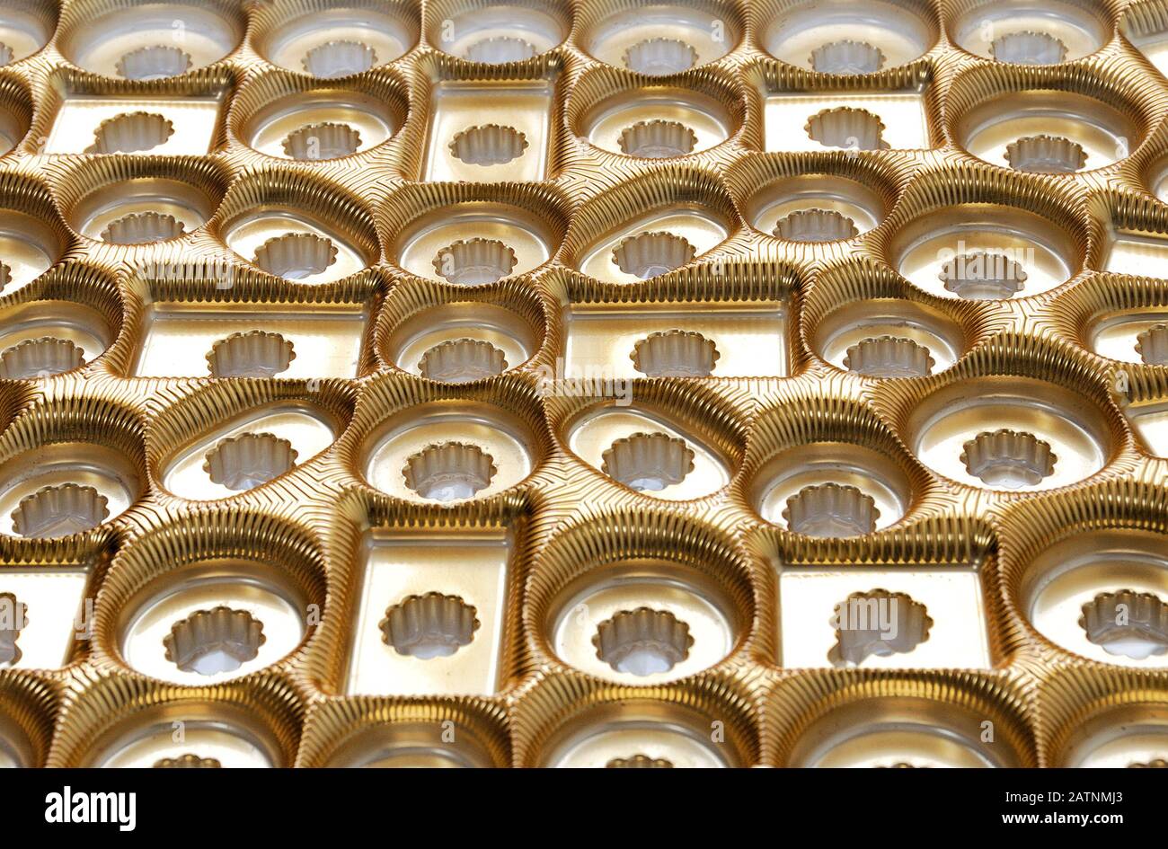 Golden plastic compartments inside chocolate gift box. Stock Photo