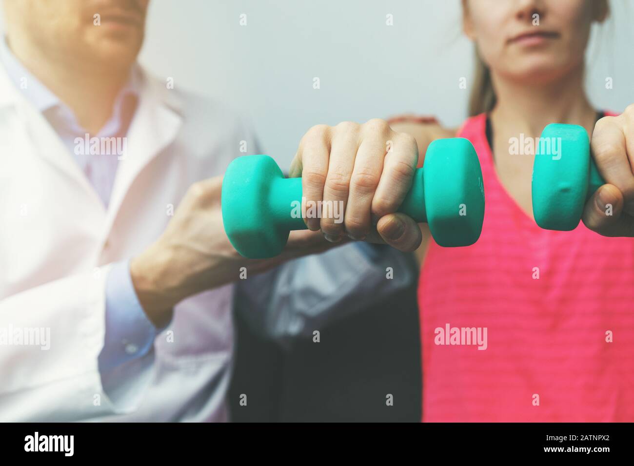 physiotherapy physiotherapist help woman patient to recover from hand injury at home. dumbbell