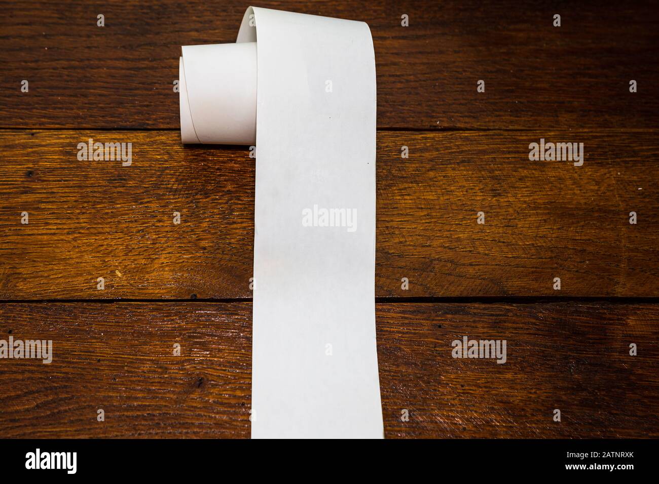 Roll of cash register tape, empty blank tax receipt on table isolated