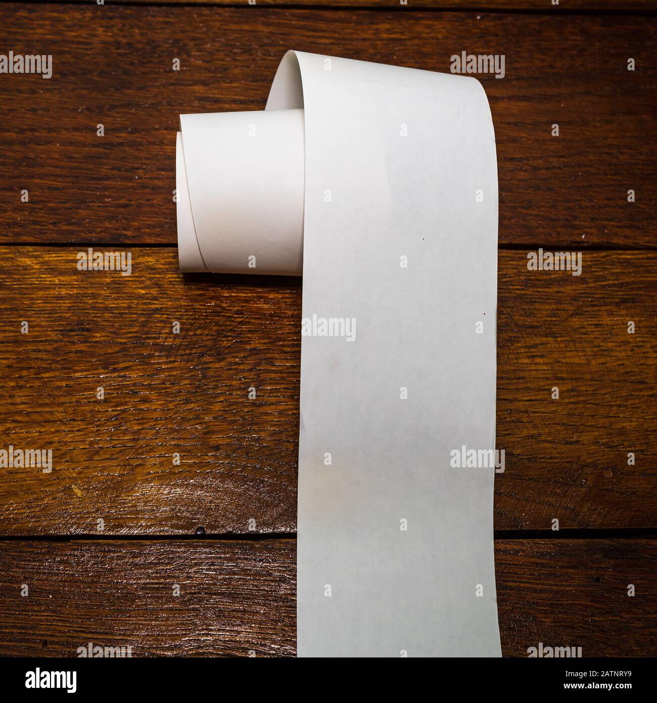 Roll of cash register tape, empty blank tax receipt on table isolated