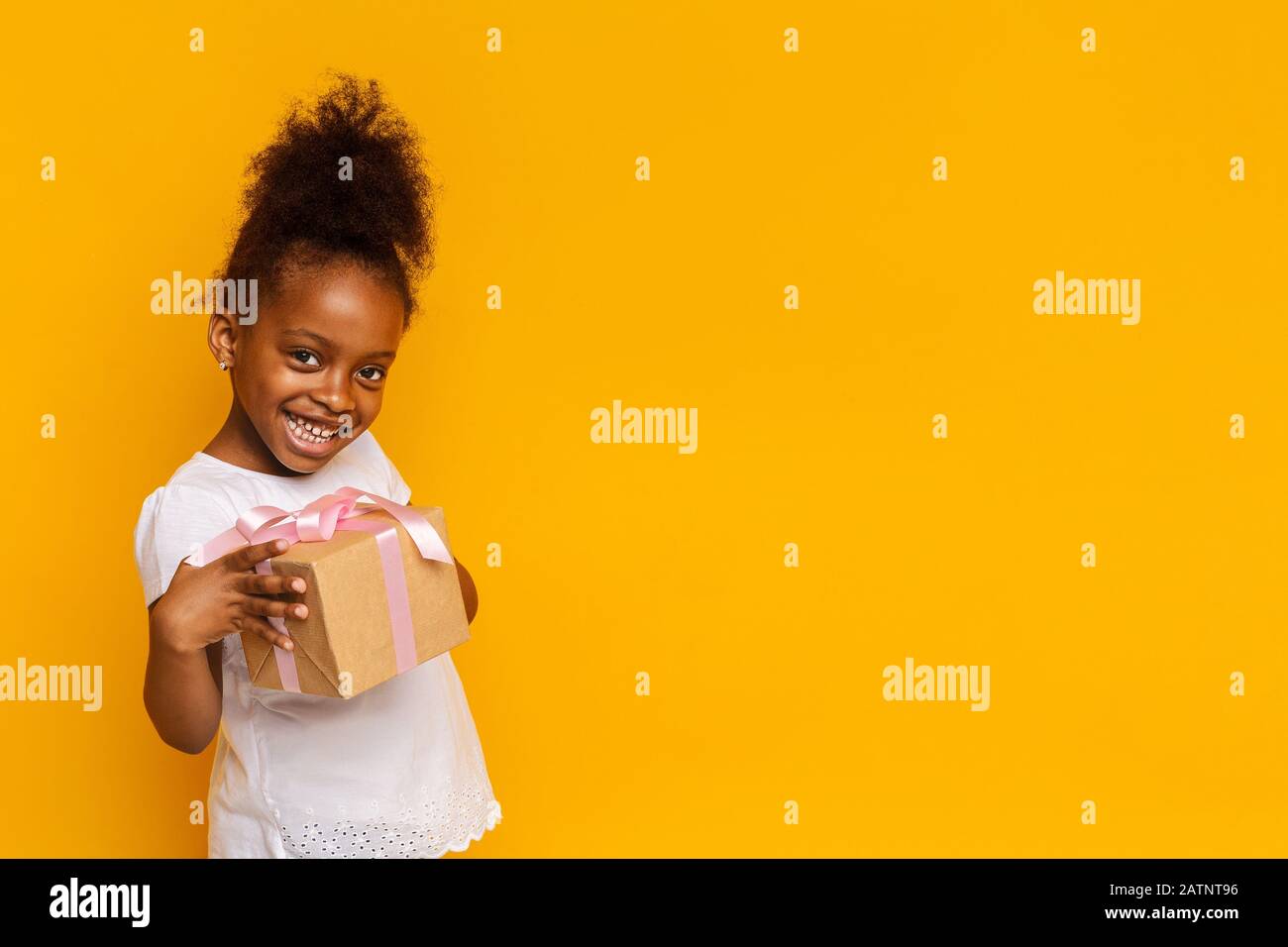 Cute little girl smiling and holding gift box Stock Photo - Alamy