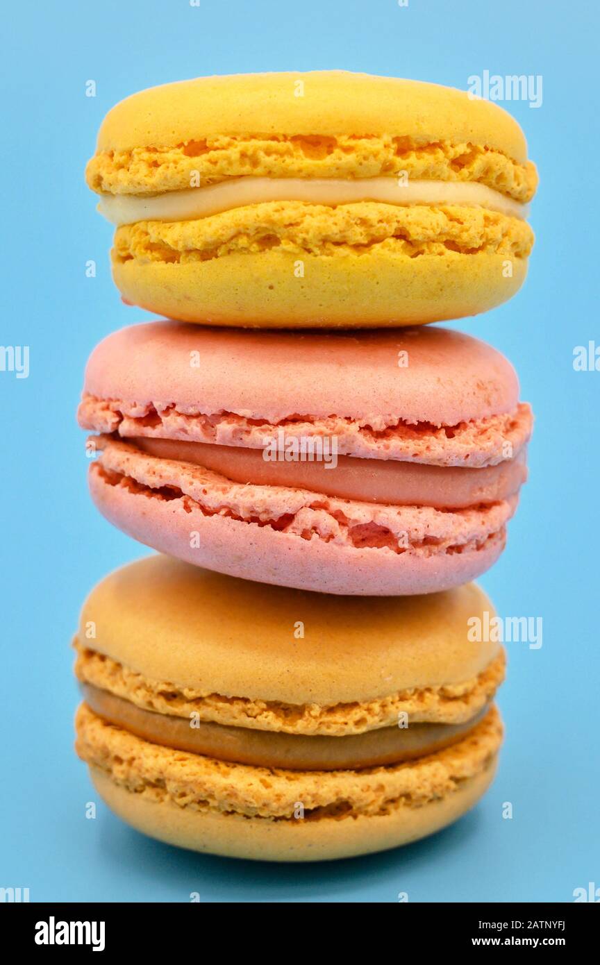 Stack of sweet french macaroons with vintage pastel colored tone on blue background . Stock Photo