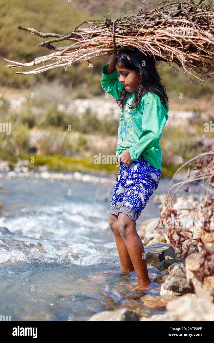 Poor young indian girl carrying clothes washing in a bundle on her head.  Andhra Pradesh, India Stock Photo - Alamy