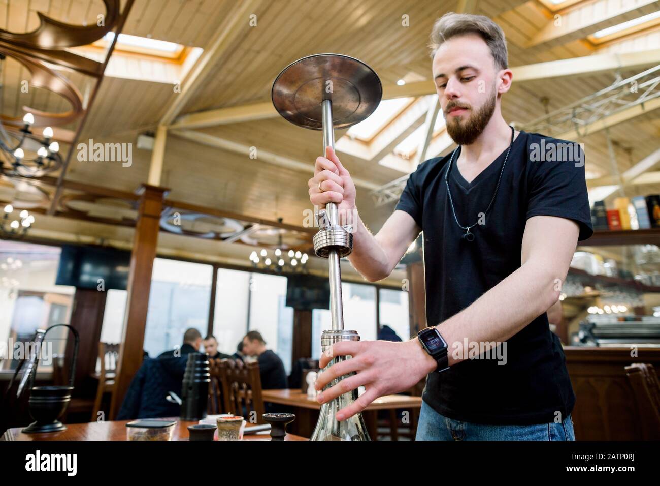 Preparing the shisha, aka nargile or hookah at a restaurant by placing the cup on top Stock Photo