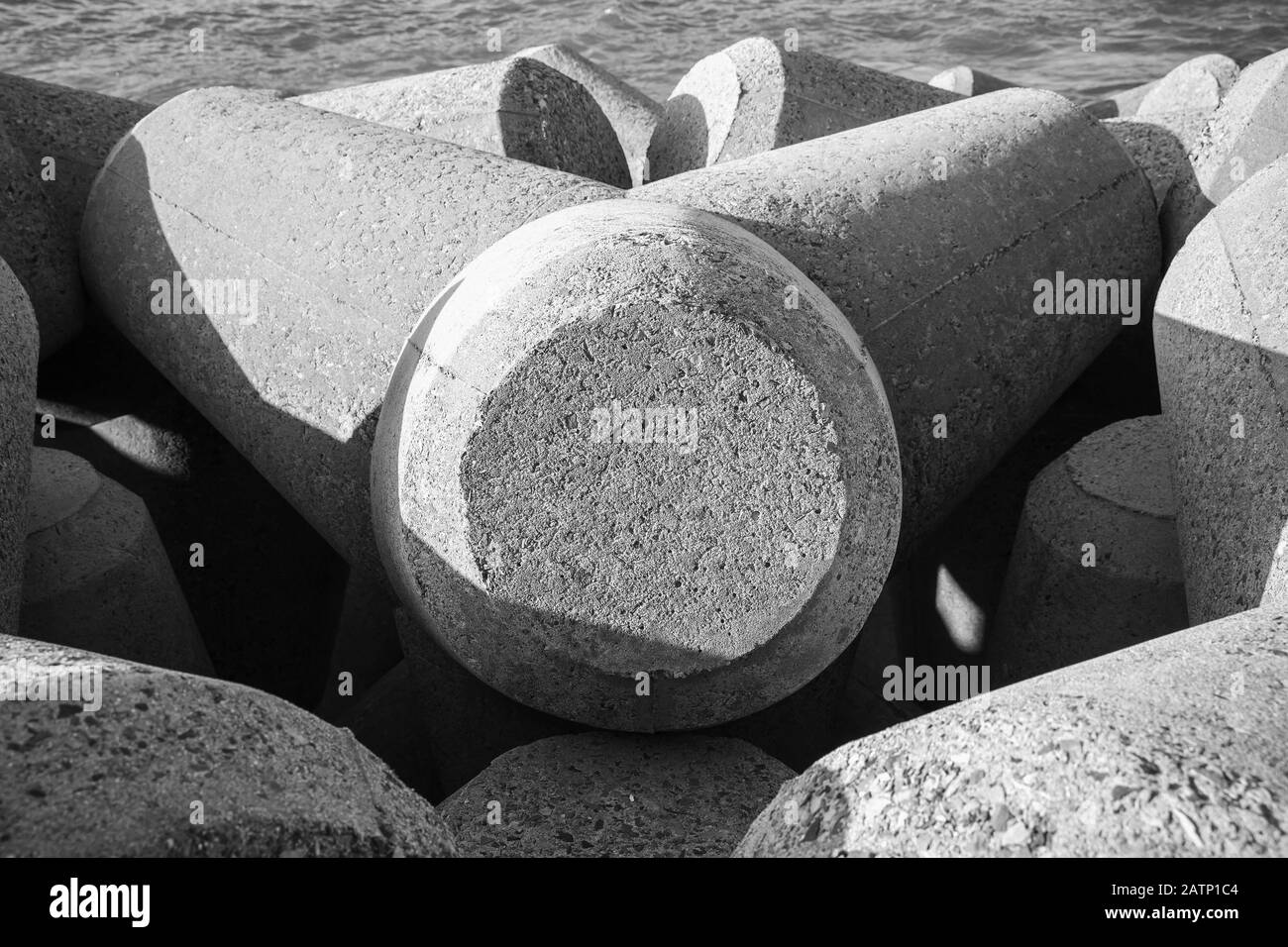 Gray concrete breakwater blocks. Background photo texture, black and white Stock Photo