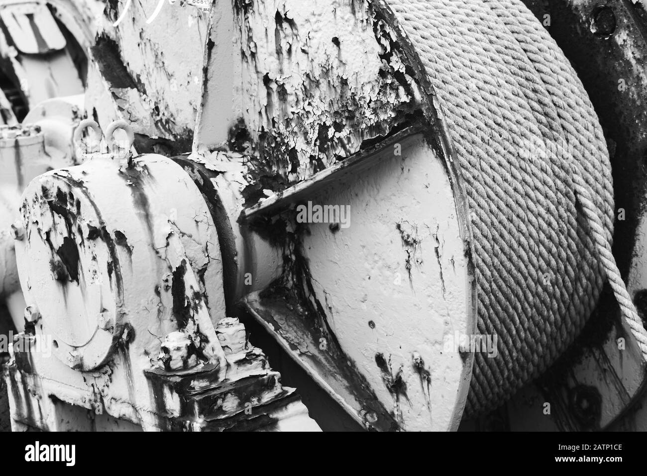 Old rusted winch reel with steel rope, black and white photo with selective focus Stock Photo