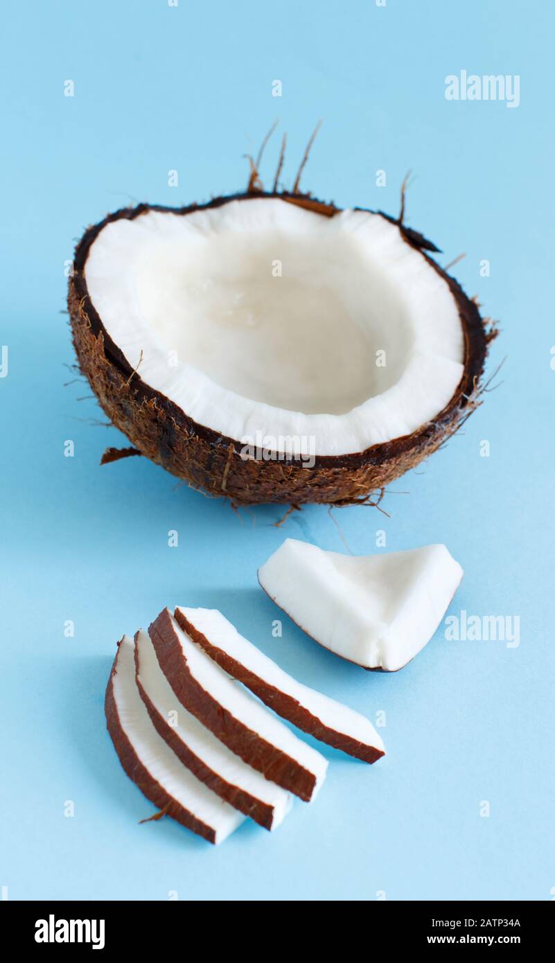 Coconut pieces on a light blue background close up Stock Photo