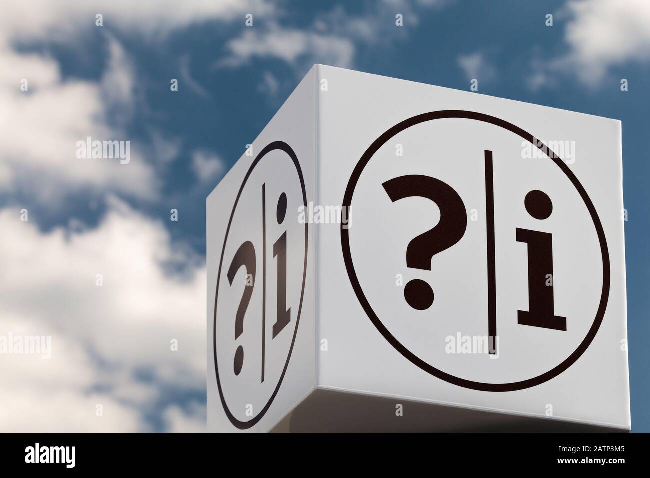 White cube shaped notice sign with question and exclamation marks against a blue cloudy sky Stock Photo