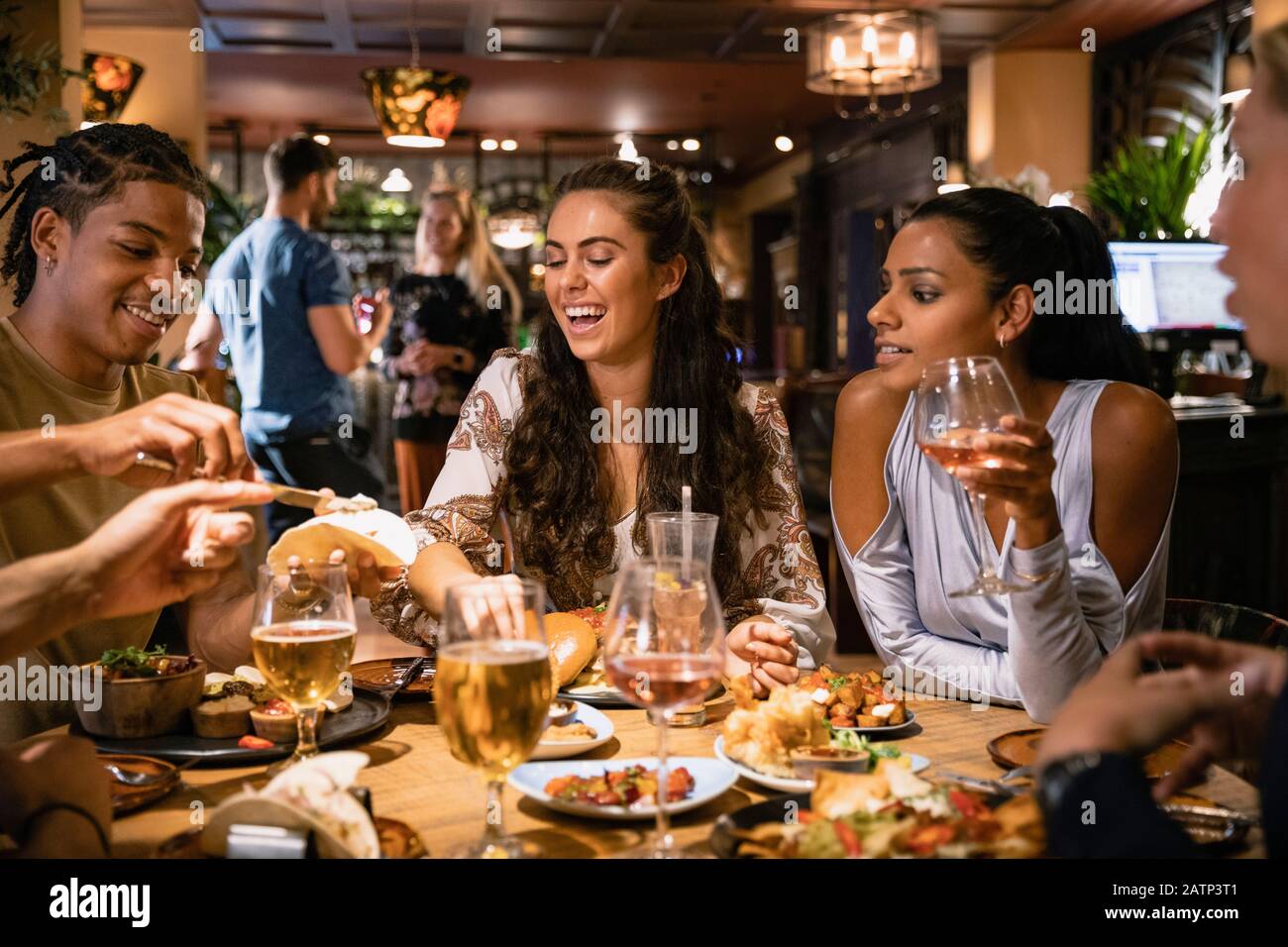 A mixed age range group of friends having a meal together at a restaurant. Stock Photo