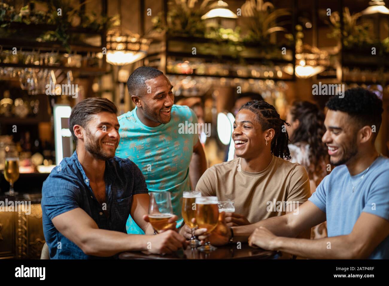 A group of male friends having a pint of beer together in a bar Stock