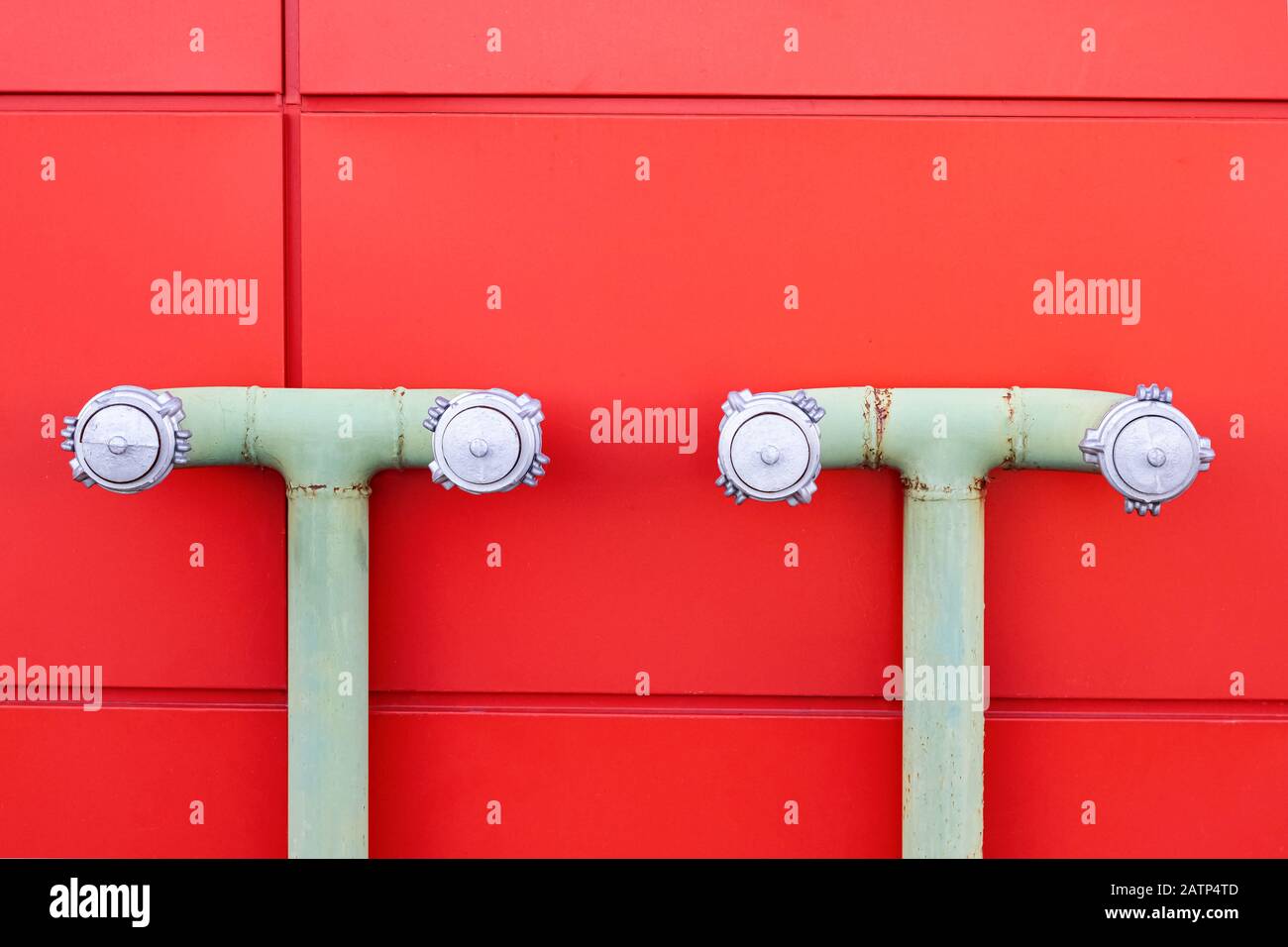 Water pipes on red wall close up Stock Photo