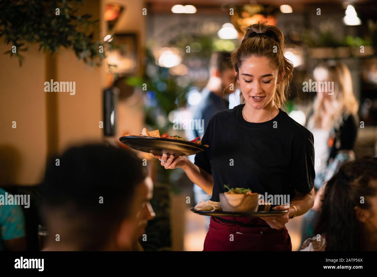 A waitress serving customers food at a restaurant in Newcastle-Upon-Tyne. Stock Photo