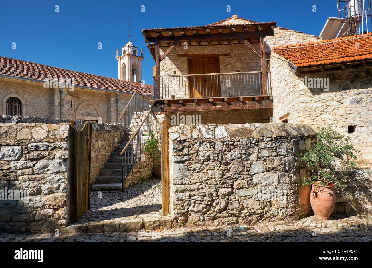 The view of the traditional old country house with the church of Virgin Mary Valas (Valana) on the  background. Lania village. Limassol. Cyprus Stock Photo