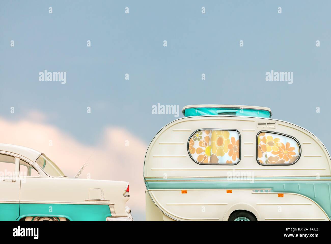 Retro classic car and seventies caravan with flower curtains in two-tone white with green Stock Photo