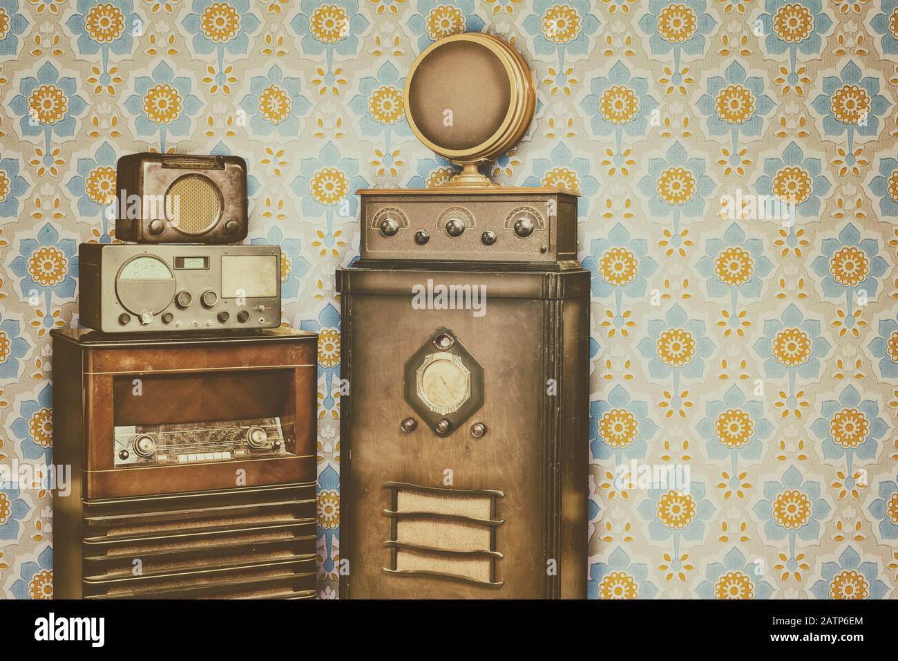 Retro styled image of old radio's in front of a retro wallpaper with flower pattern Stock Photo
