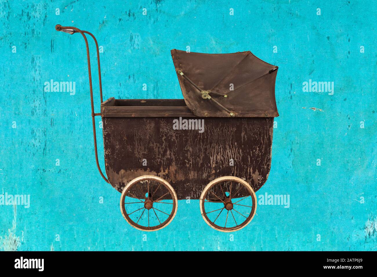 Vintage baby stroller in front of a blue eroded background Stock Photo