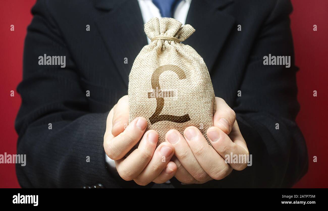 A man holds out a pound sterling money bag. Bank deposit. Budget management, tax collection. Trade, economics. Granting financing business project or Stock Photo