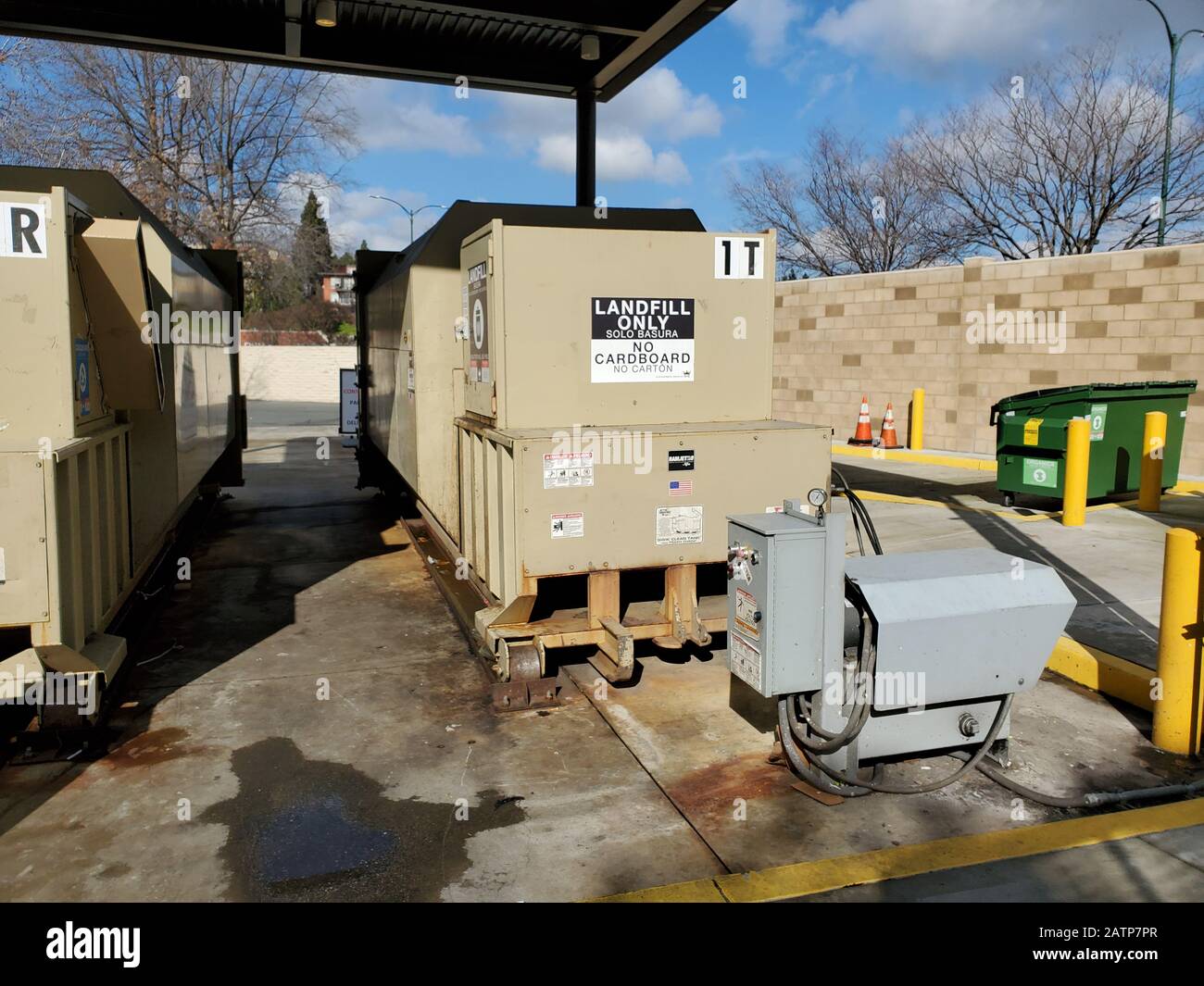 Garbage compactor and dumpsters at a commercial facility in Walnut