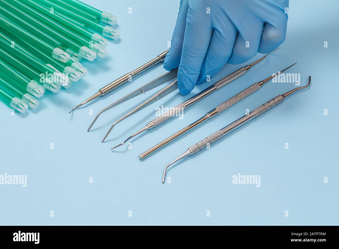 Dentist's hand in a rubber glove and set of dental instruments for ...