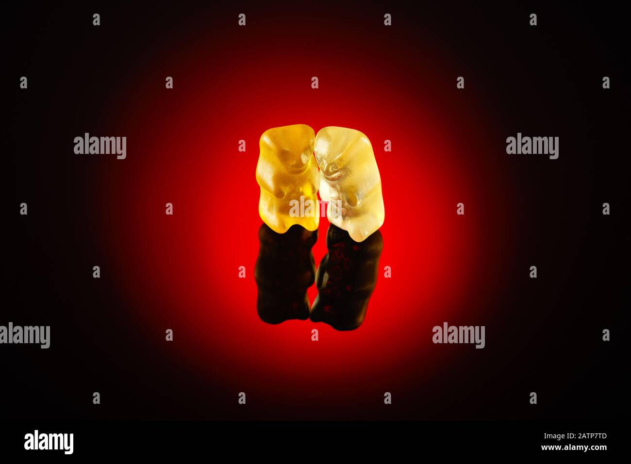 Two gummy bears under the red spotlight. Concept of friendship, love or intimacy Stock Photo