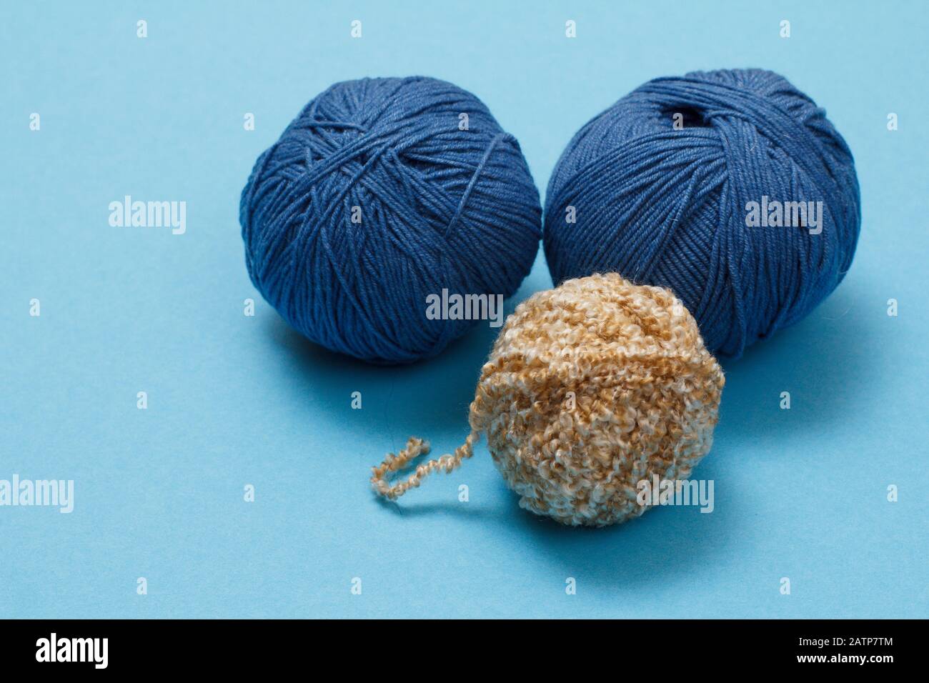 Knitting yarn balls on a blue background. Knitting concept. Top view. Stock Photo