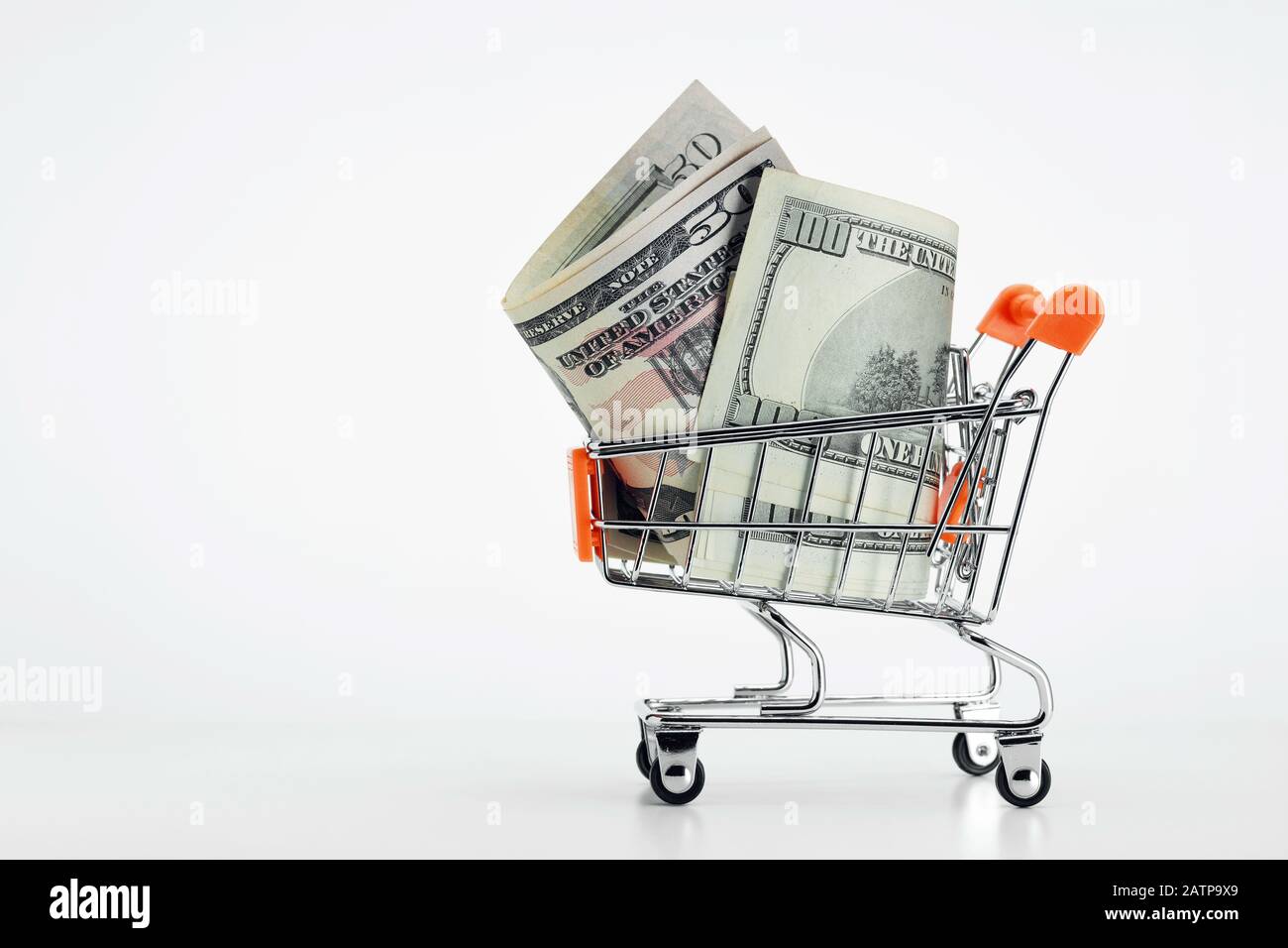 Shopping cart trolley full of dollar bills on white background. Concept