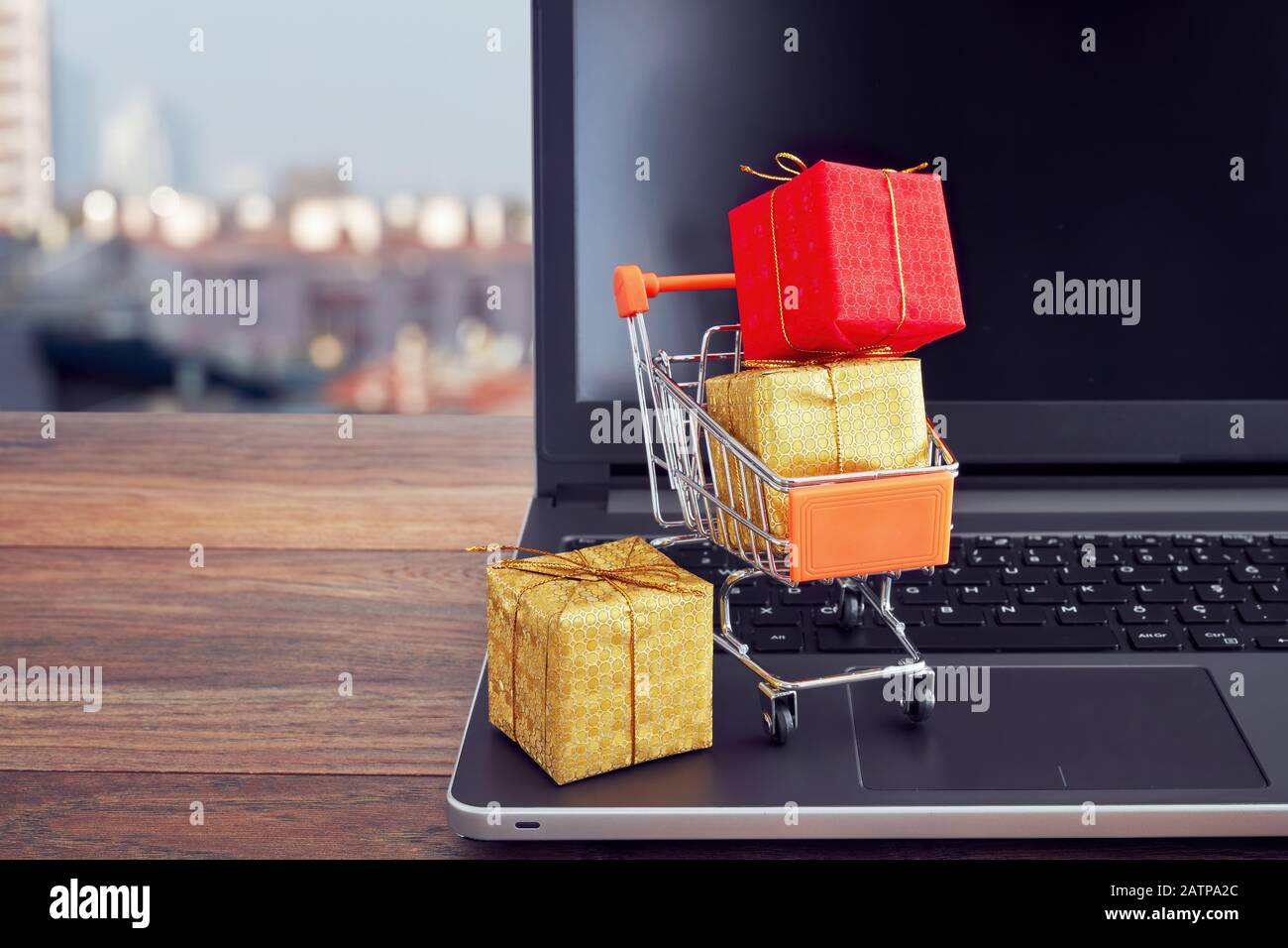 Shopping cart trolley full of colorful gift boxes on a laptop computer. Concept of online shopping for christmas or special days. Stock Photo