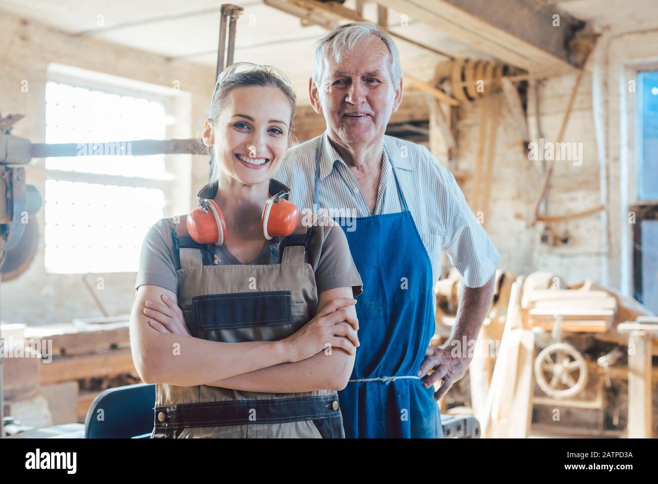 Senior master carpenter with his granddaughter in the wood workshop Stock Photo