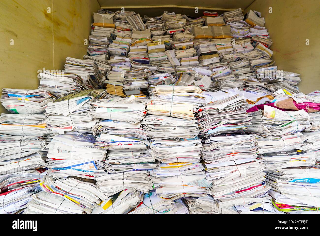 A horizontal view of stacks of paper and magazines and newspapers ready