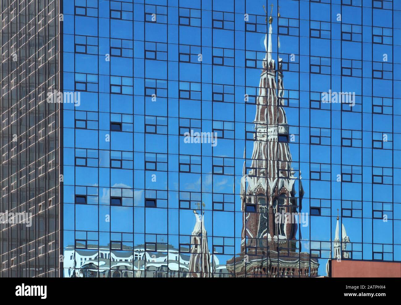 Old and new. Silhouette of a church reflecting in the facade of a modern building. Stock Photo