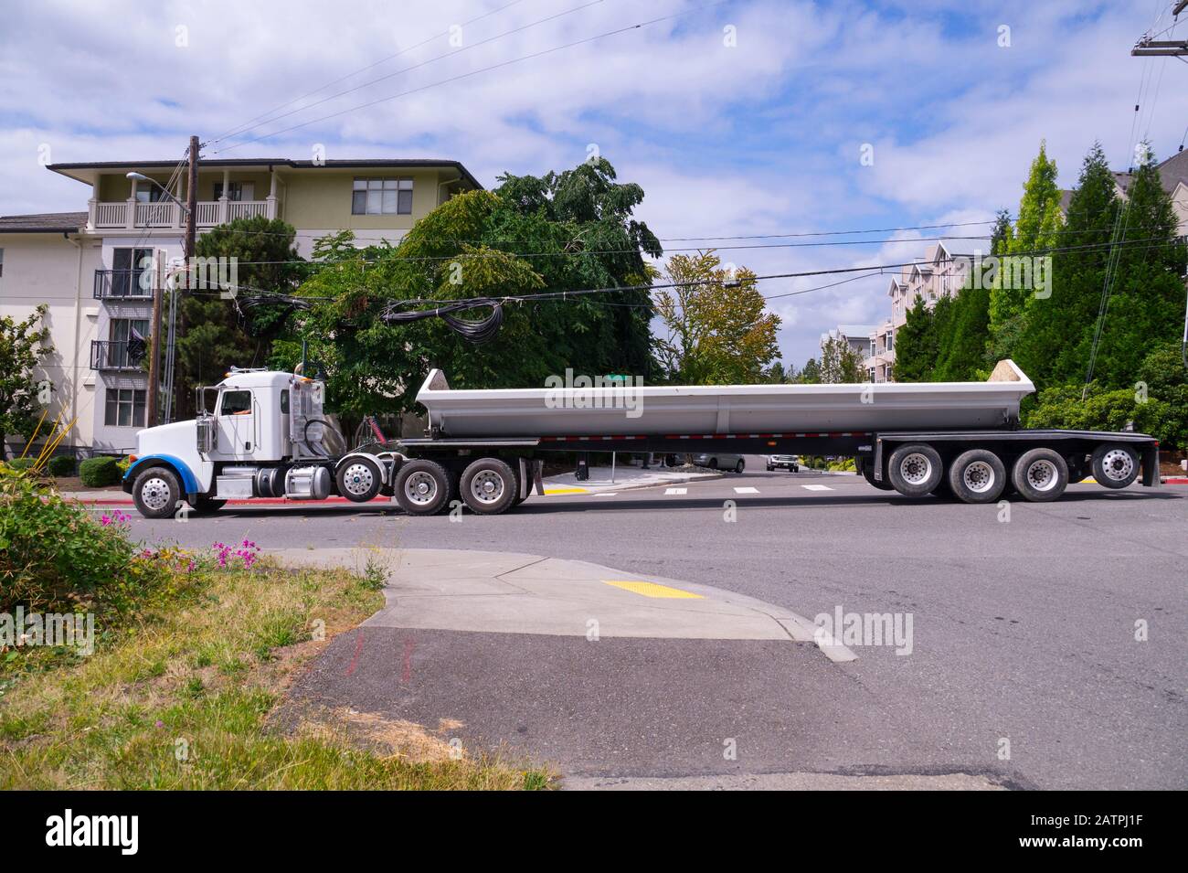 Side Dump trailer truck. A large vehicle in city traffic. Stock Photo