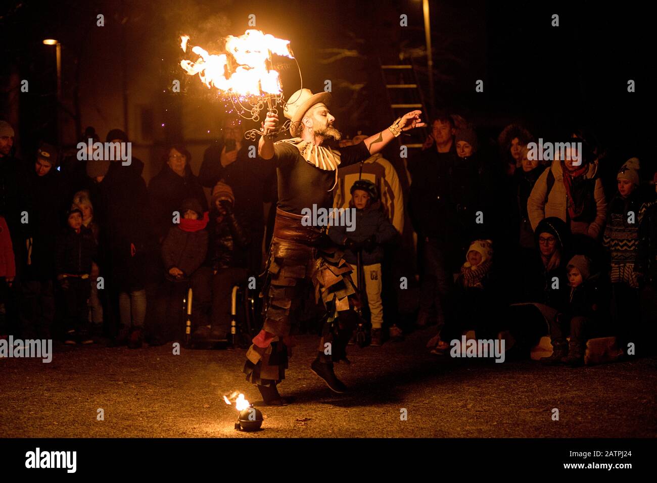 Street artist with a burning stick during his dangerous fire show, Ana Mraz, International Winter Street Theatre festival in Ljubljana, Slovenia Stock Photo