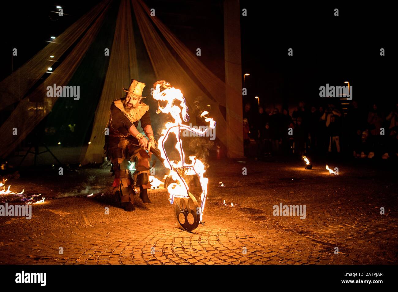 Street artist with a burning stick during his dangerous fire show, Ana Mraz, International Winter Street Theatre festival in Ljubljana, Slovenia Stock Photo