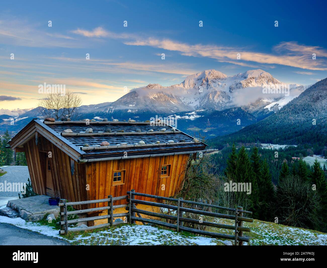 Traditional wooden hut, behind it the massif of the Hohen Goell in winter, Berchtesgaden National Park, Schoenau am Koenigssee, Berchtesgadener Land Stock Photo