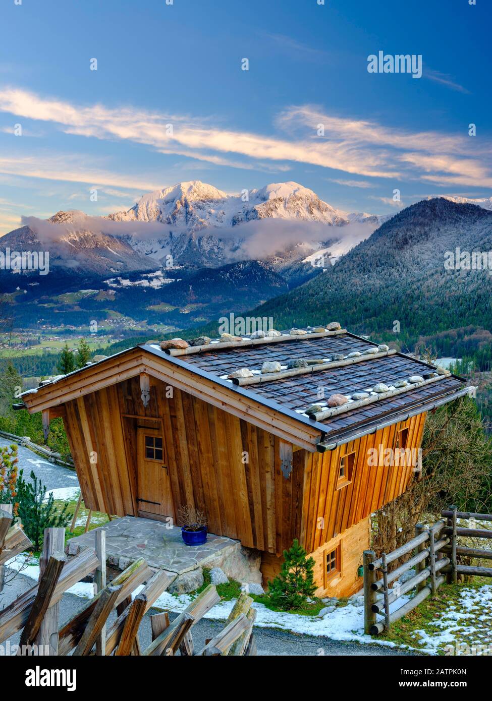 Traditional wooden hut, behind it the massif of the Hohen Goell in winter, Berchtesgaden National Park, Schoenau am Koenigssee, Berchtesgadener Land Stock Photo