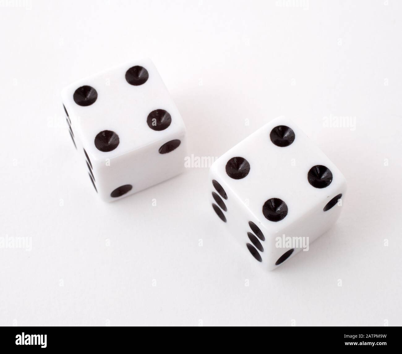 Two dice rolling 8, shot against a white background Stock Photo