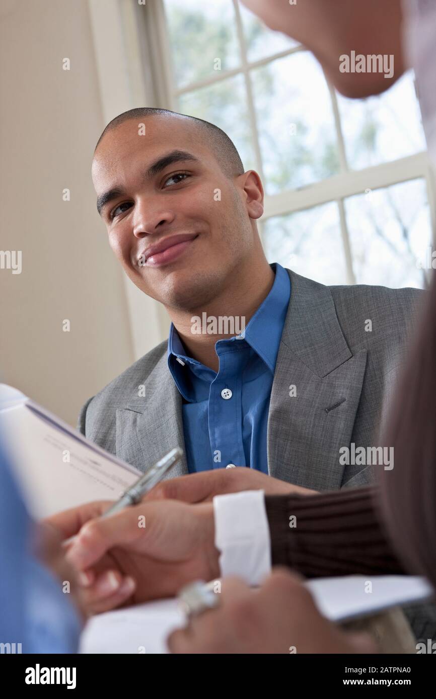 Young professionals working together at a table reviewing documents Stock Photo